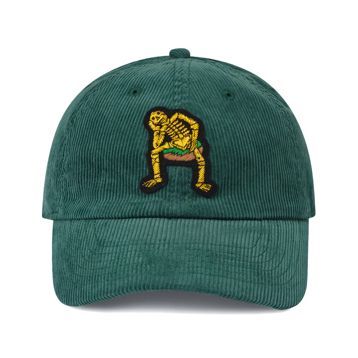 Green corduroy hat with hand-embroidered wire bullion Derry Bones badge.